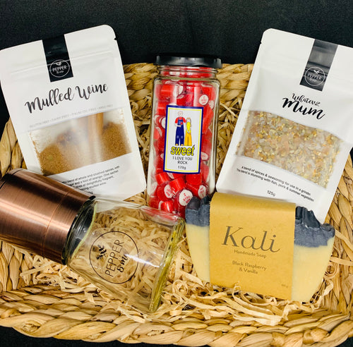 A gift basket with spices, soap, sweets and a pepper grinder
