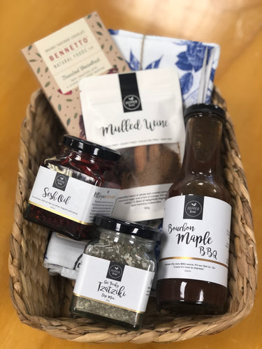 A gift basket with oil, sauce, spices and more