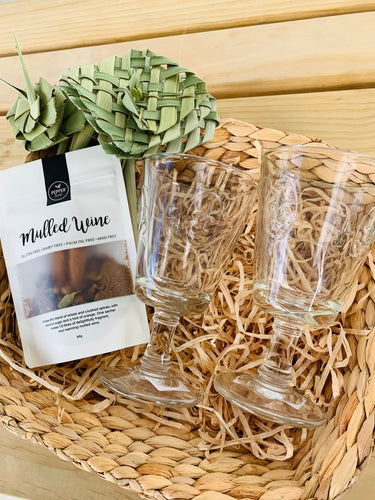 A gift basket with mulled wine spices and two glasses