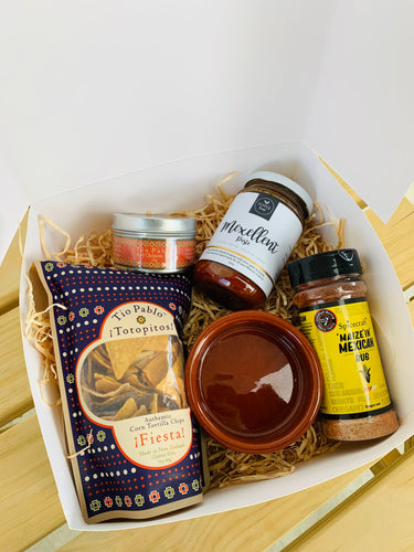 A gift box with tortilla chips, rub, paste and salsa